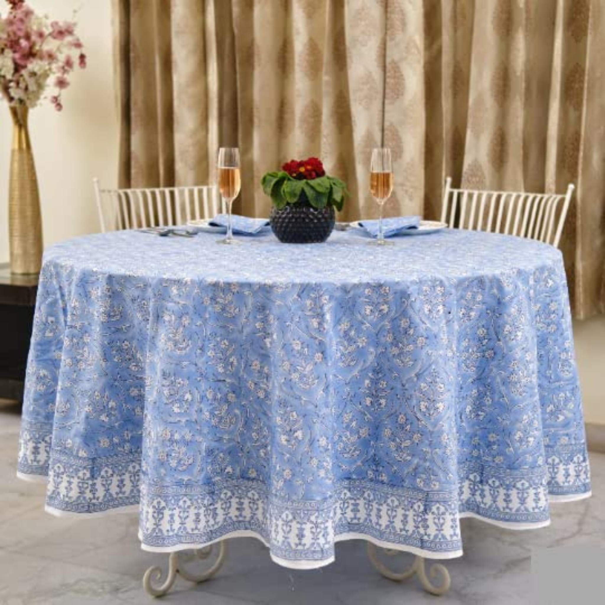Round table with a blue floral-patterned tablecloth in an elegant setting.