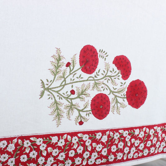 Embroidered tablecloth with red floral design on a white background