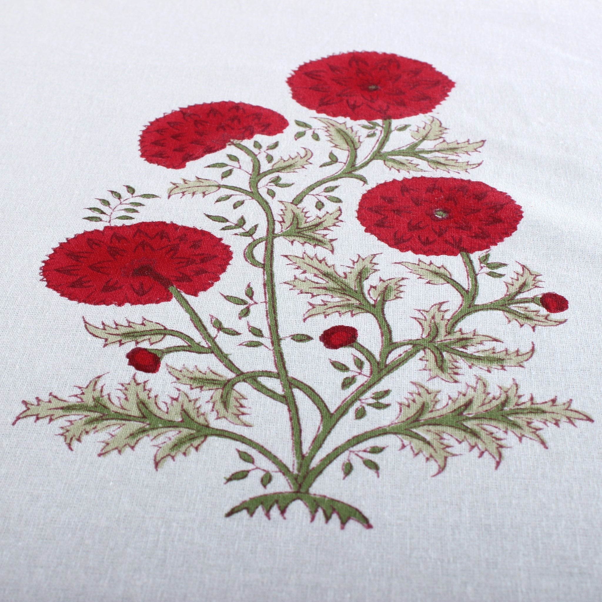 Embroidered design of red flowers on a white fabric background
