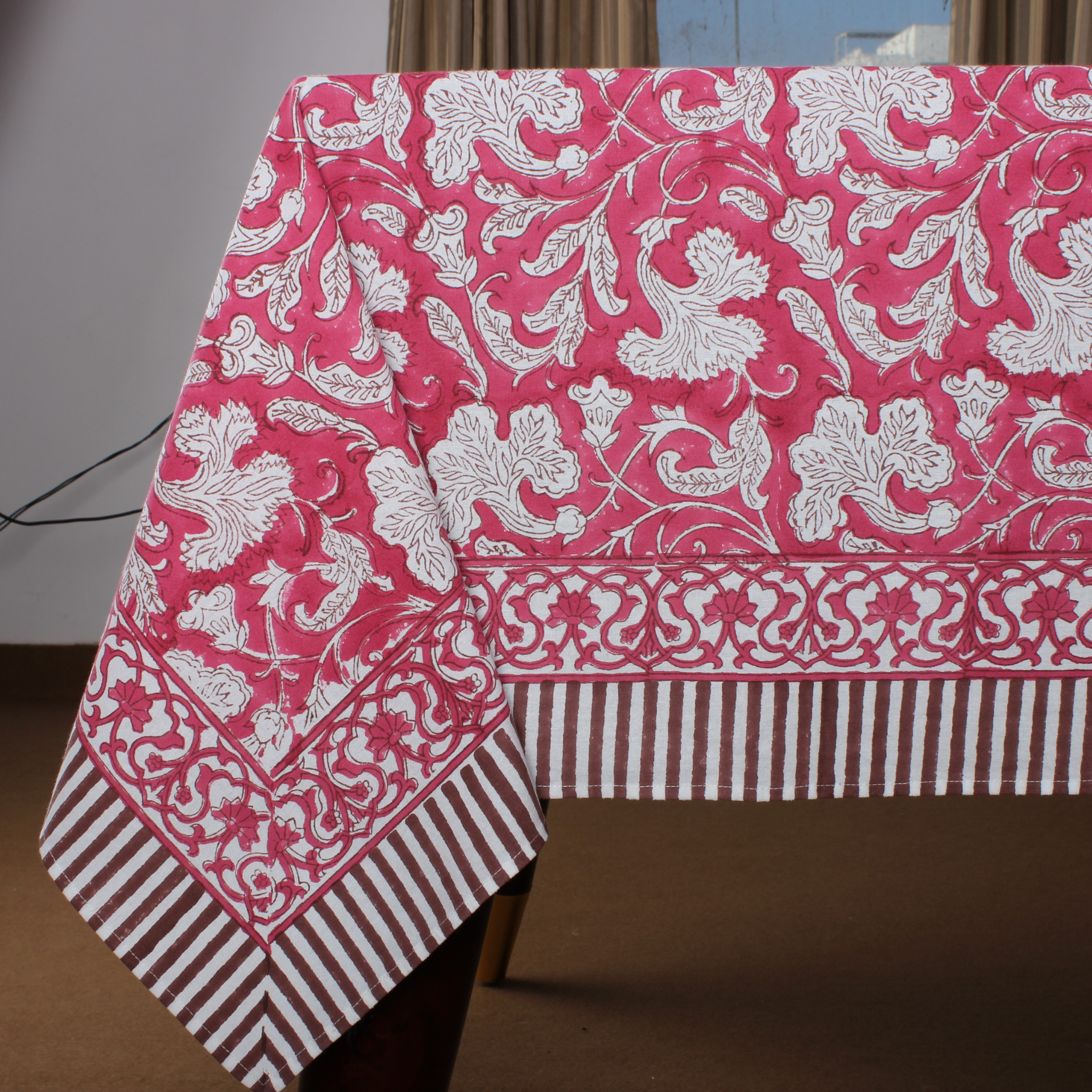 Pink and white patterned tablecloth on a table with a brown background