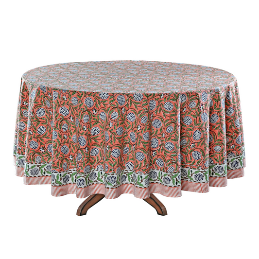 Round table with a floral patterned tablecloth on a white background