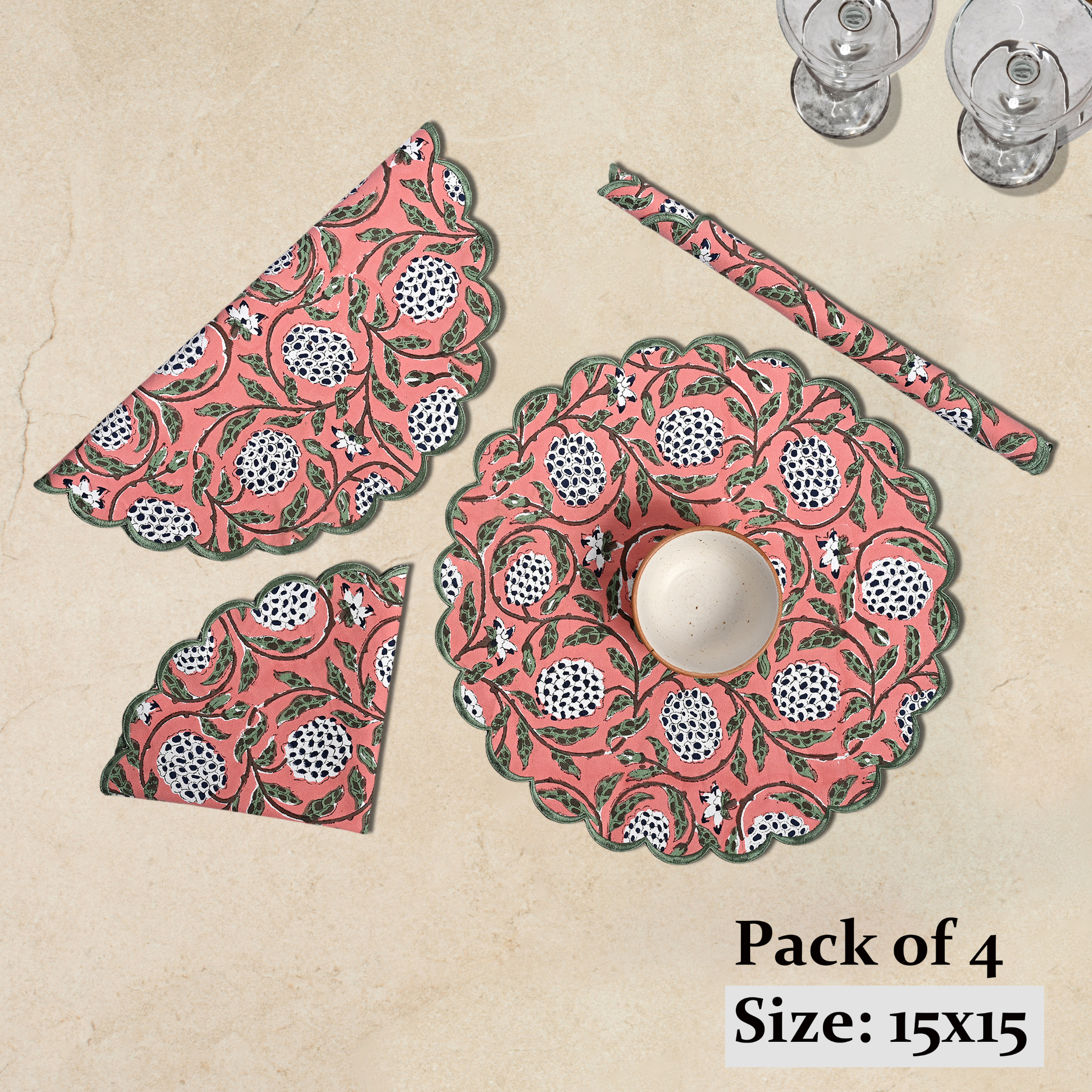 Set of pink and green patterned placemats and coasters on a beige background