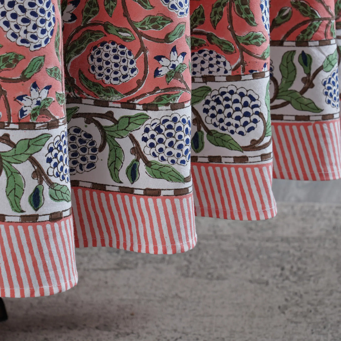 Close-up of patterned fabric with floral and striped designs on a neutral background
