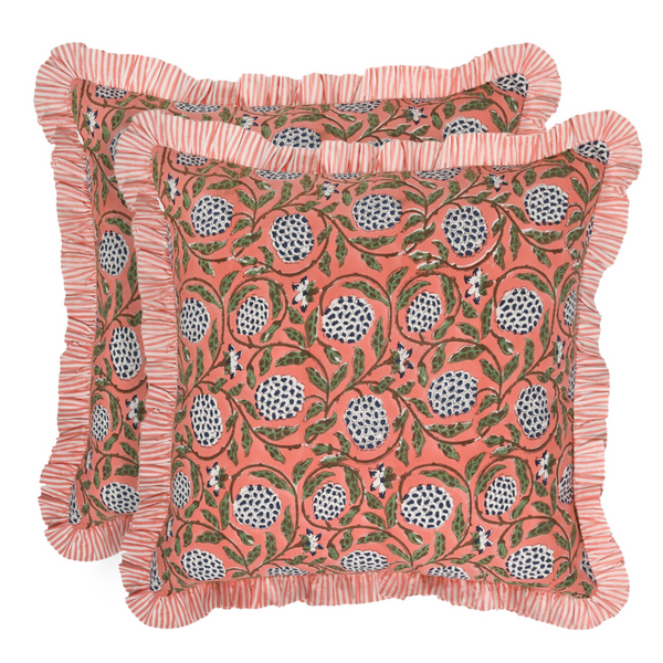 Decorative pillow with floral pattern and ruffled edge on a white background