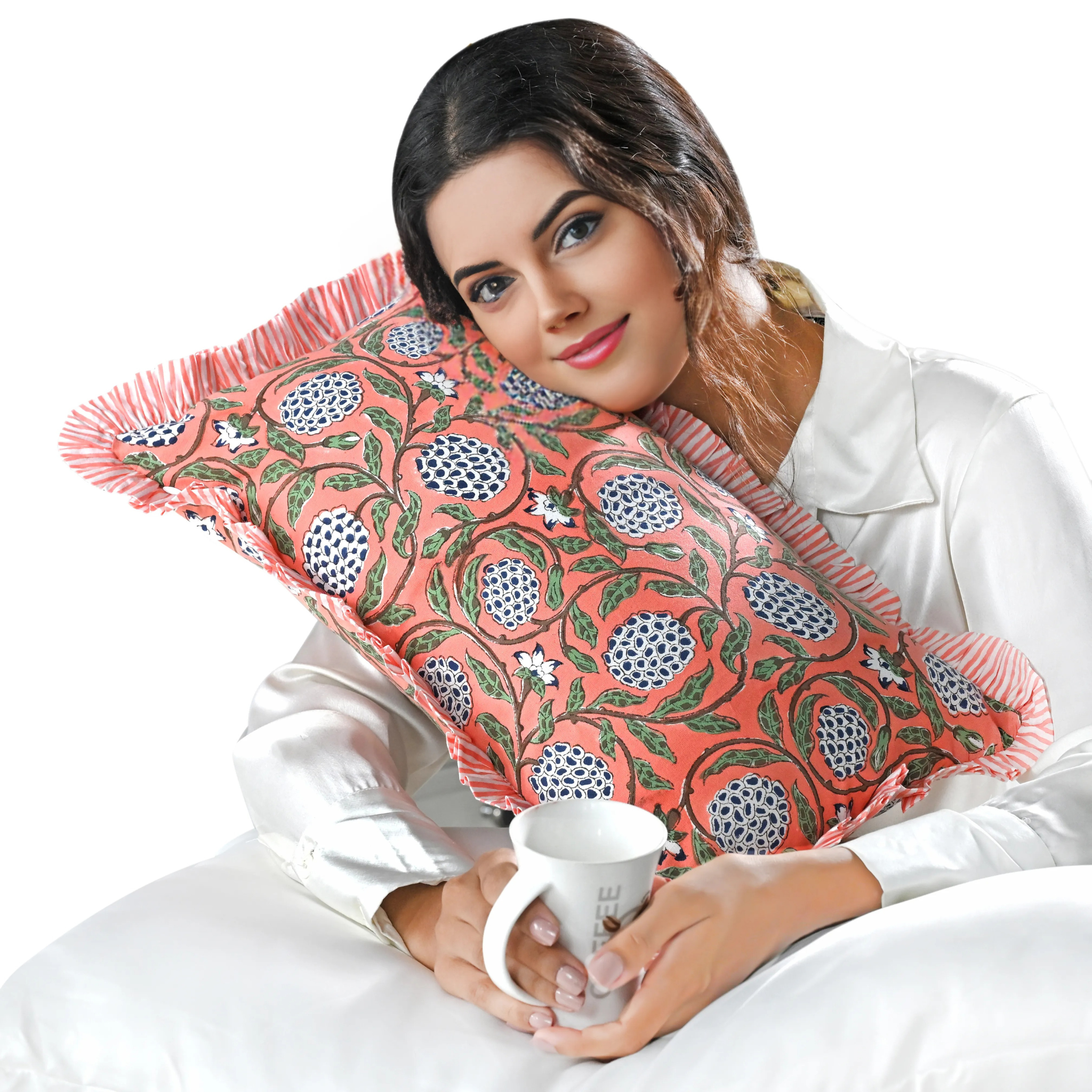 Woman holding a decorative pillow with floral patterns and a mug on a white background