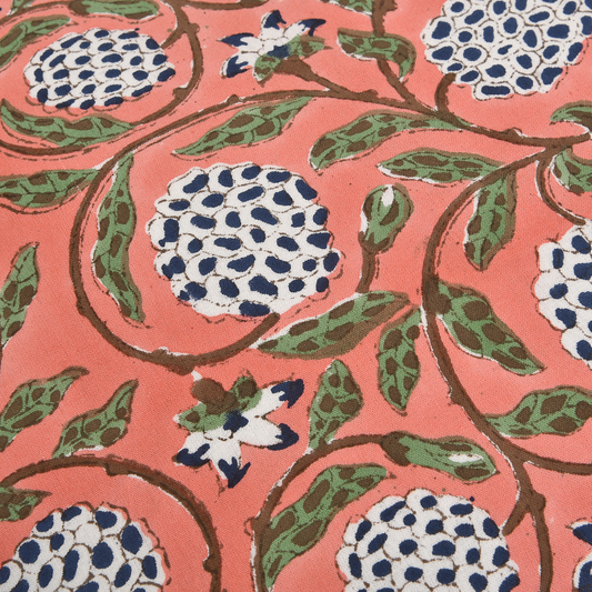 Patterned fabric with blue and white floral design on a pink background