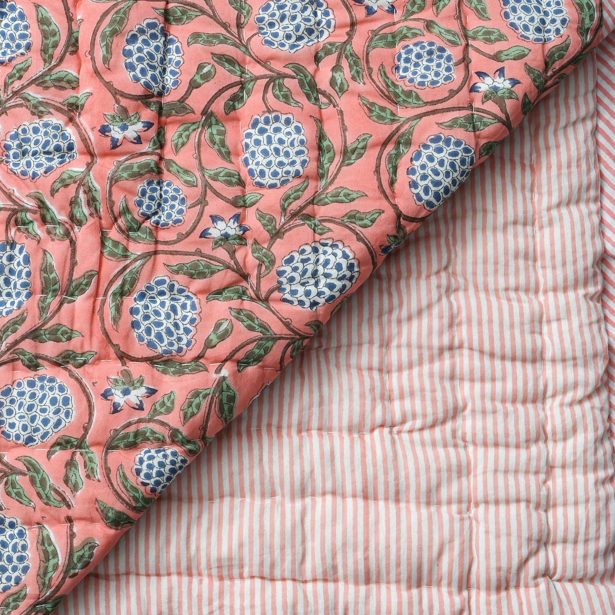 Quilt with floral pattern on a striped fabric background