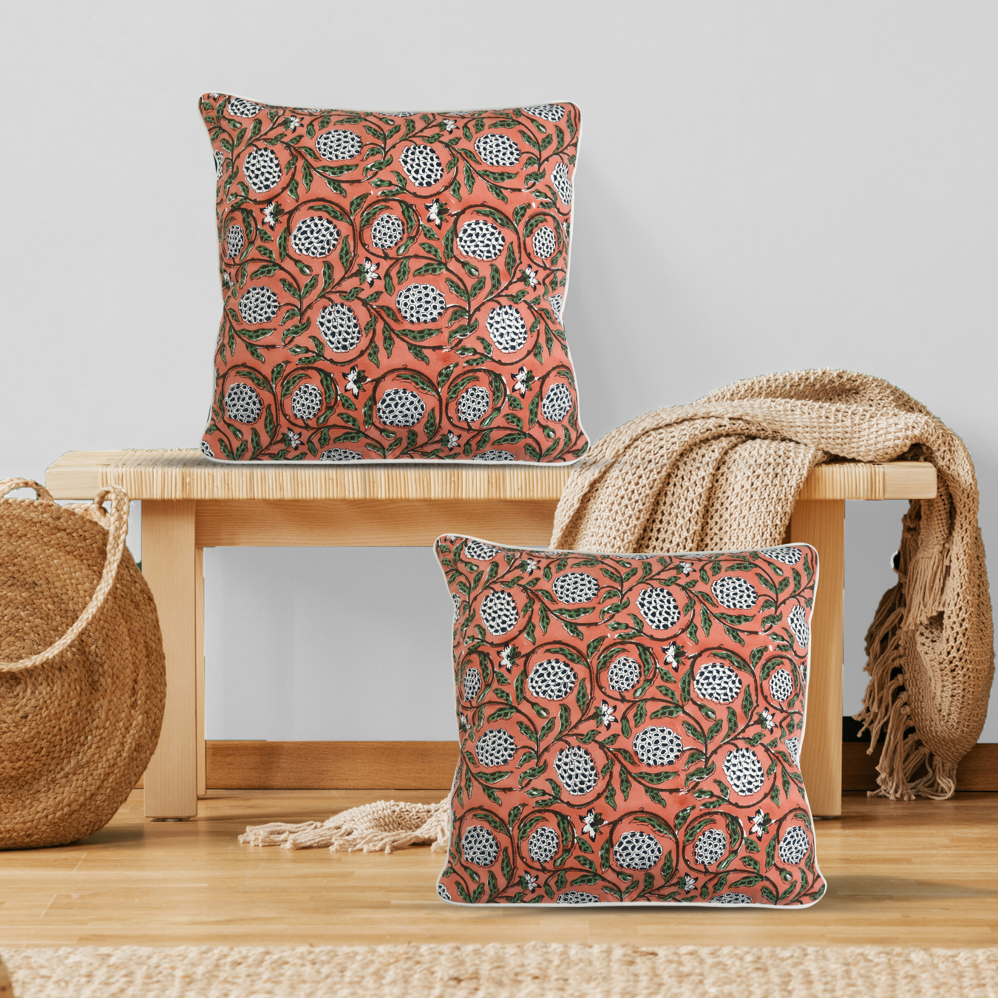 Decorative pillows with a floral pattern on a wooden bench and surface.