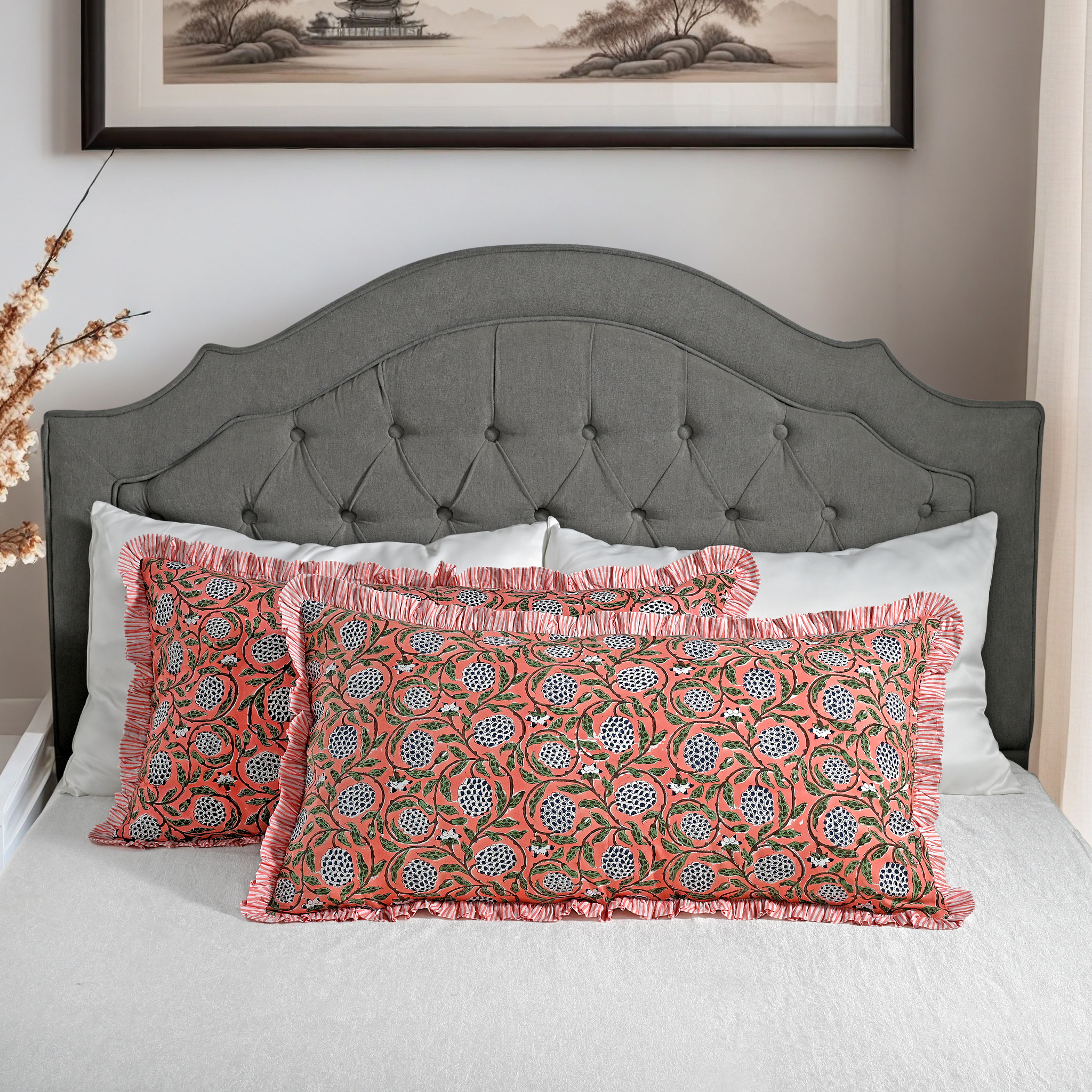 Large block print cotton pillows styled on gray upholstered bed.