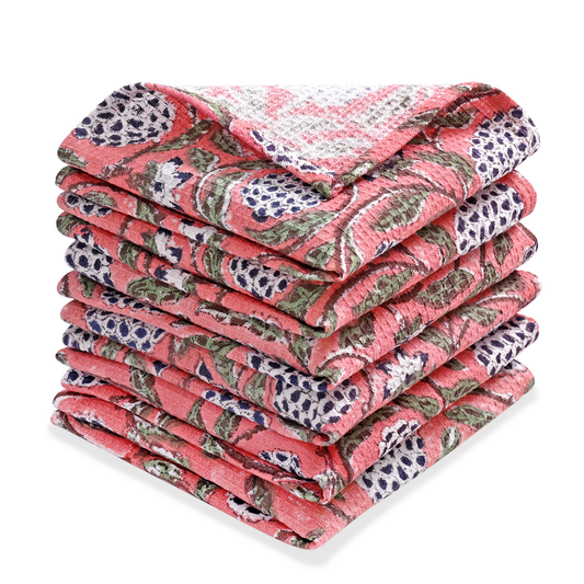 Stack of pink floral patterned towels on a white background