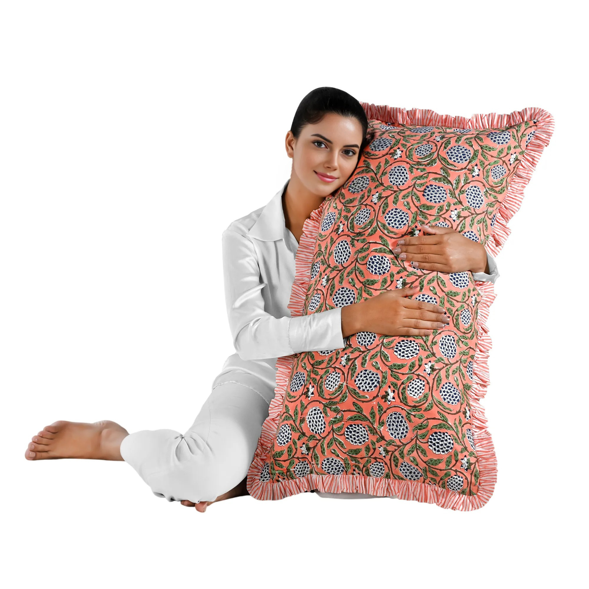 Woman holding a large pink floral block print cotton pillow with green edges.