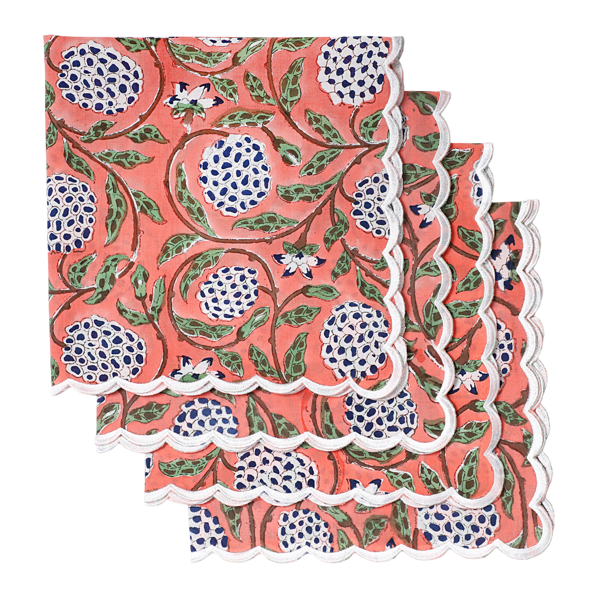 Set of three floral patterned napkins with scalloped edges on a white background