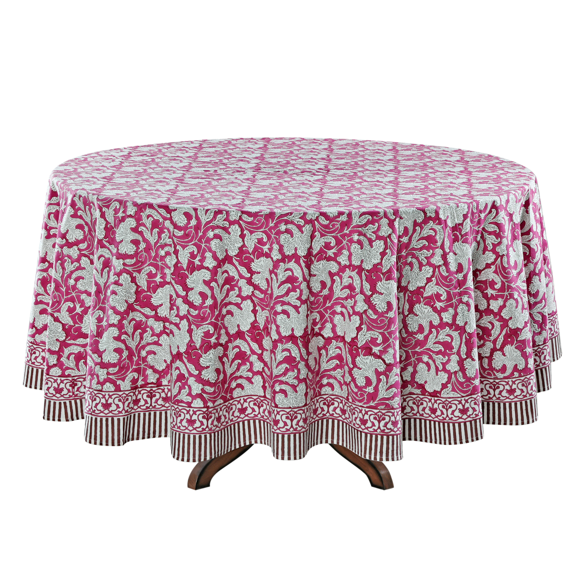 Round table with a pink and white patterned tablecloth on a white background