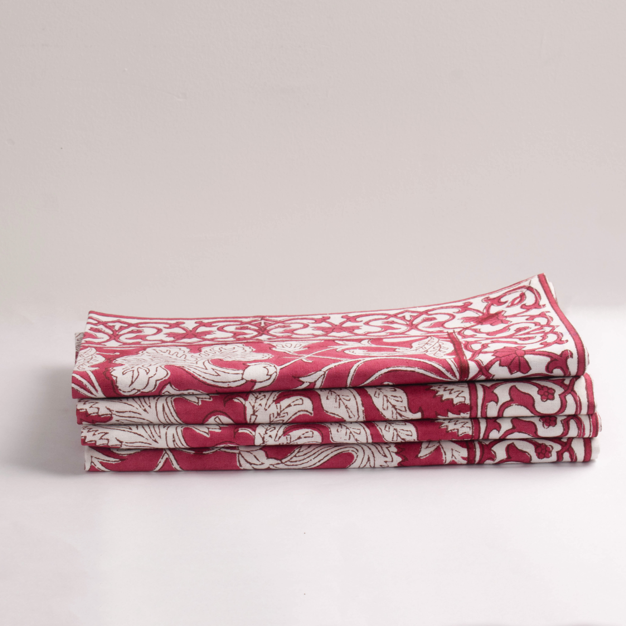 Stack of red and white patterned napkins on a light gray background