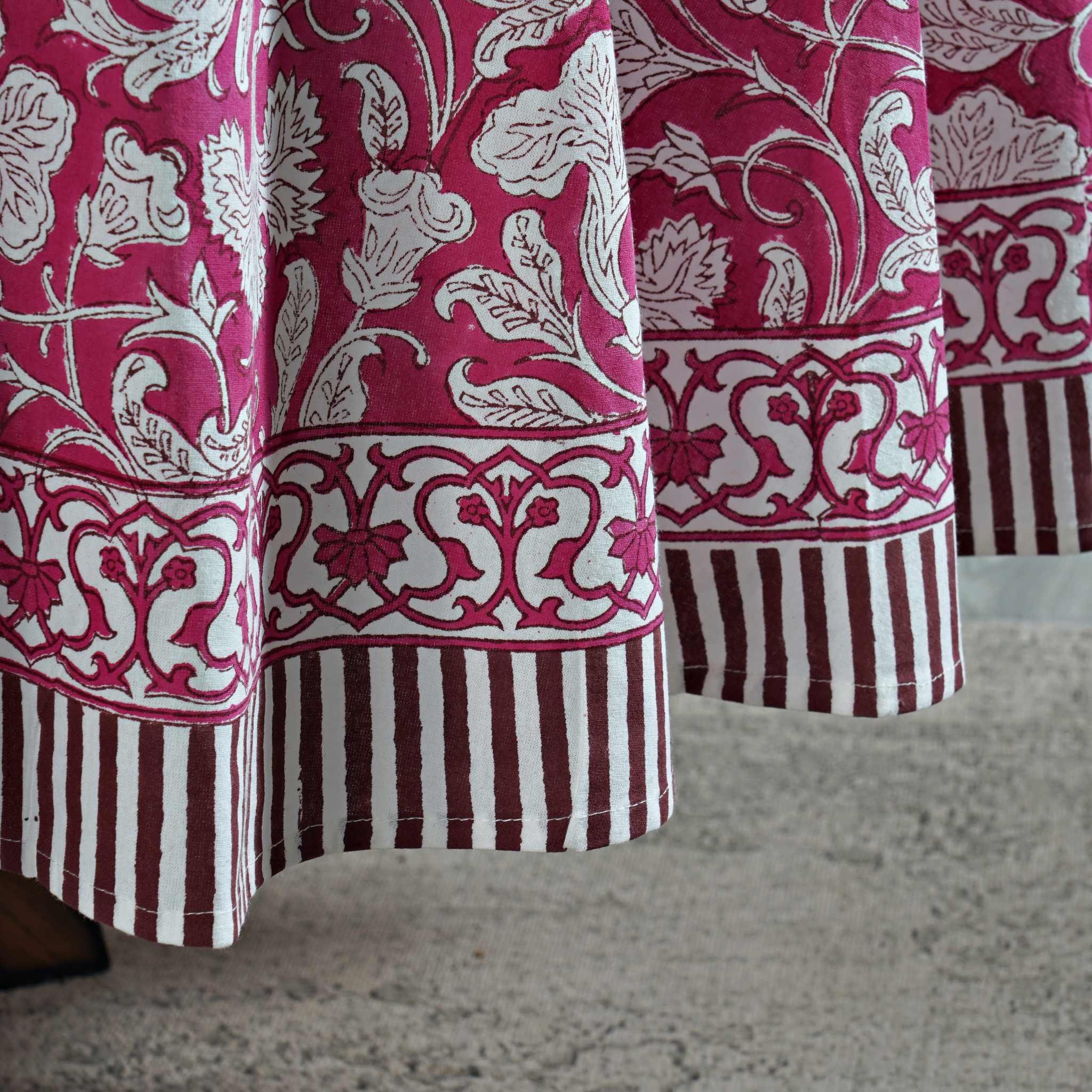 Close-up of patterned fabric with pink and white design on a neutral background