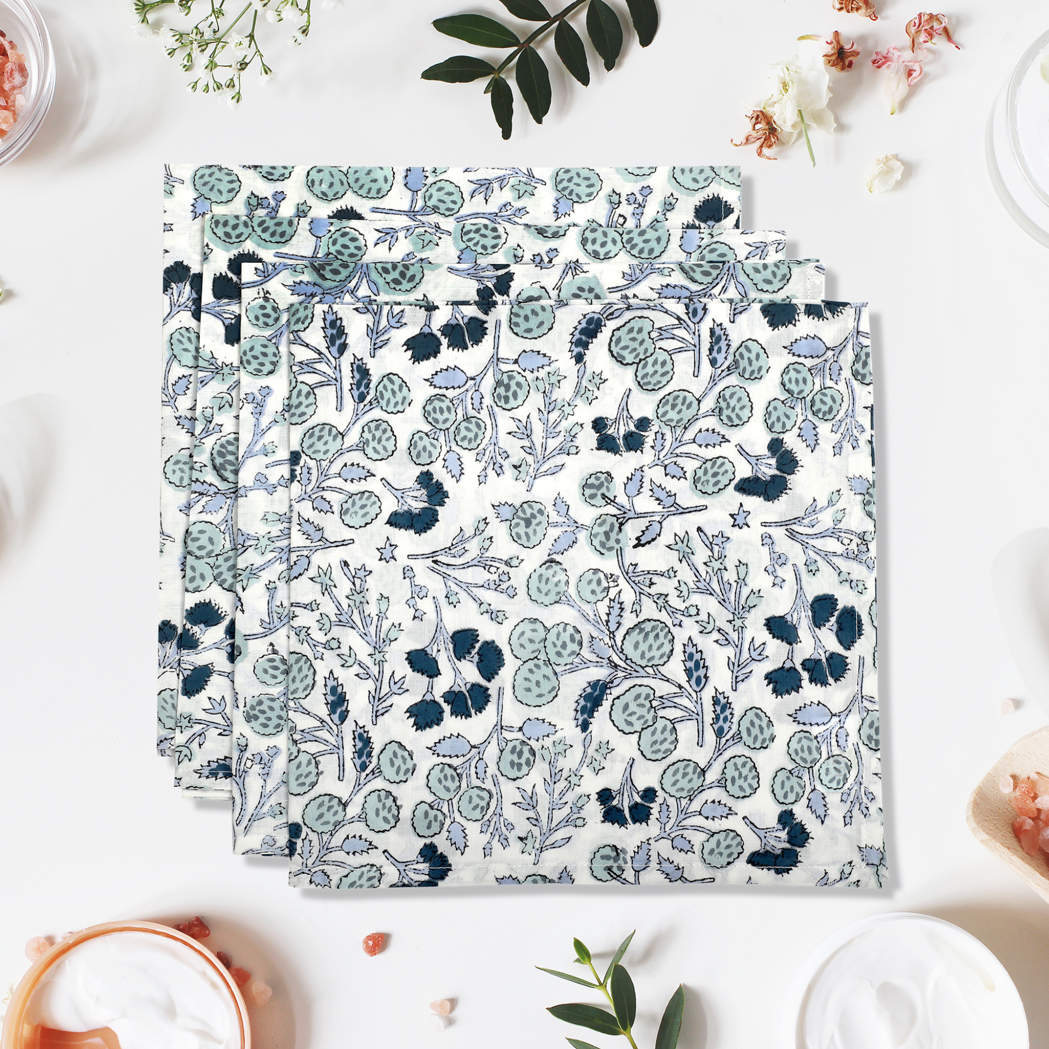 Set of floral-patterned placemats on a white surface with decorative elements.