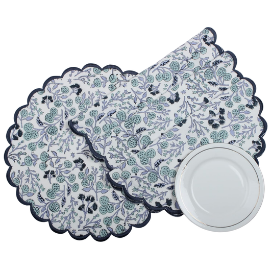 Set of floral patterned placemats with a white plate on a white background