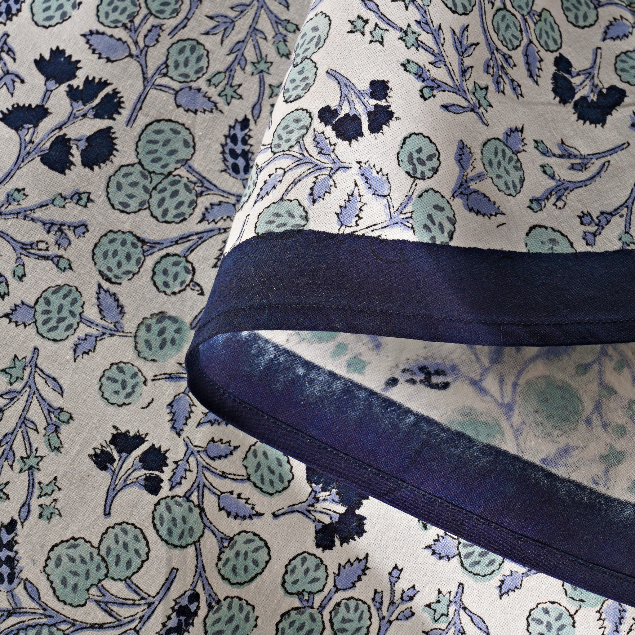 Close-up of fabric with floral pattern and blue trim