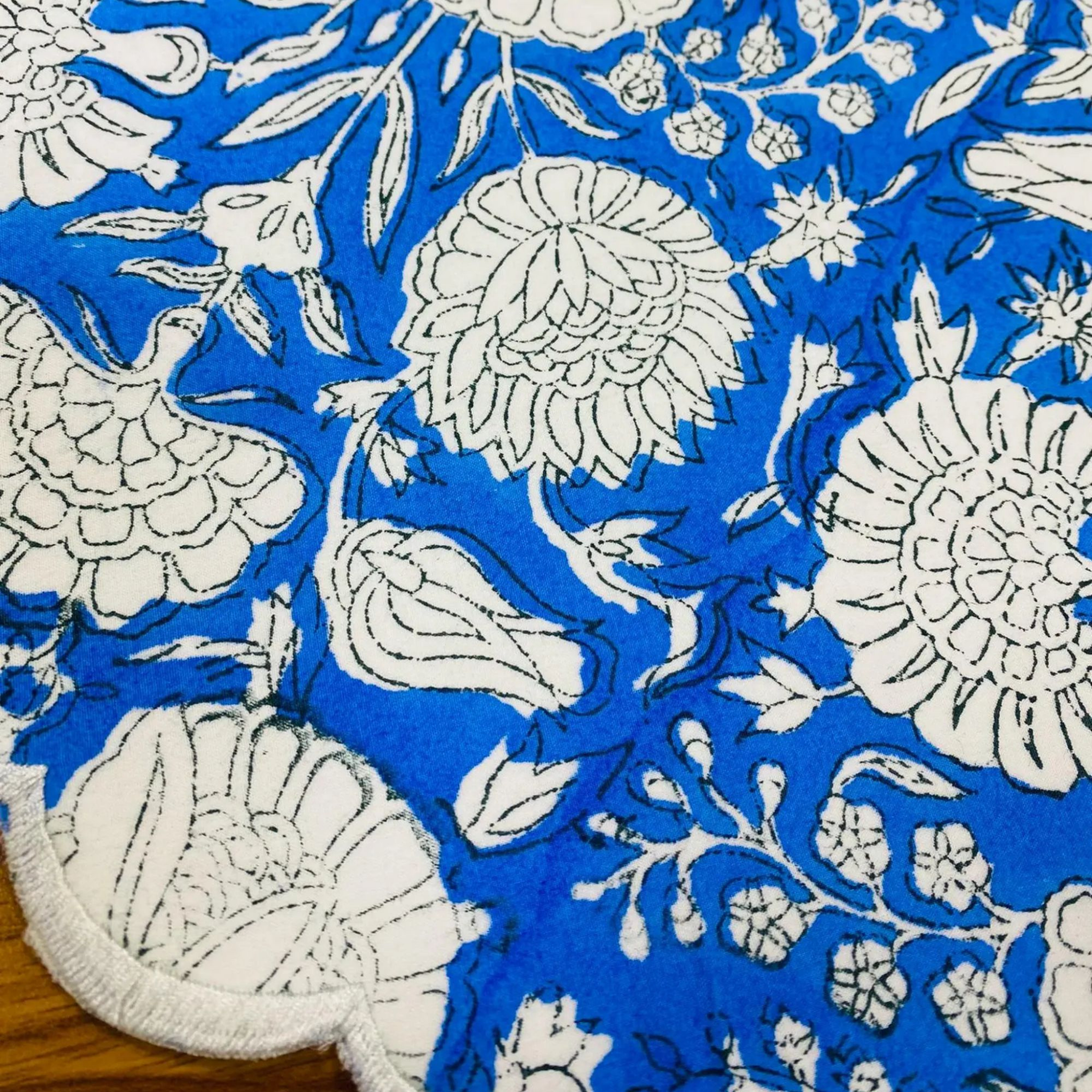 Blue fabric with white floral patterns on a wooden surface