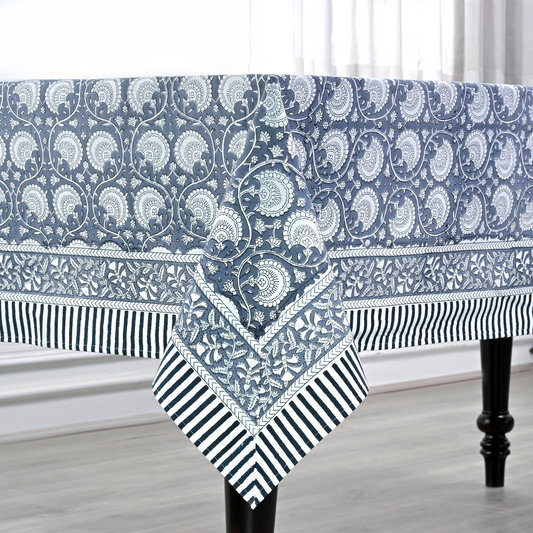 Blue and white patterned tablecloth on a dining table with a neutral background