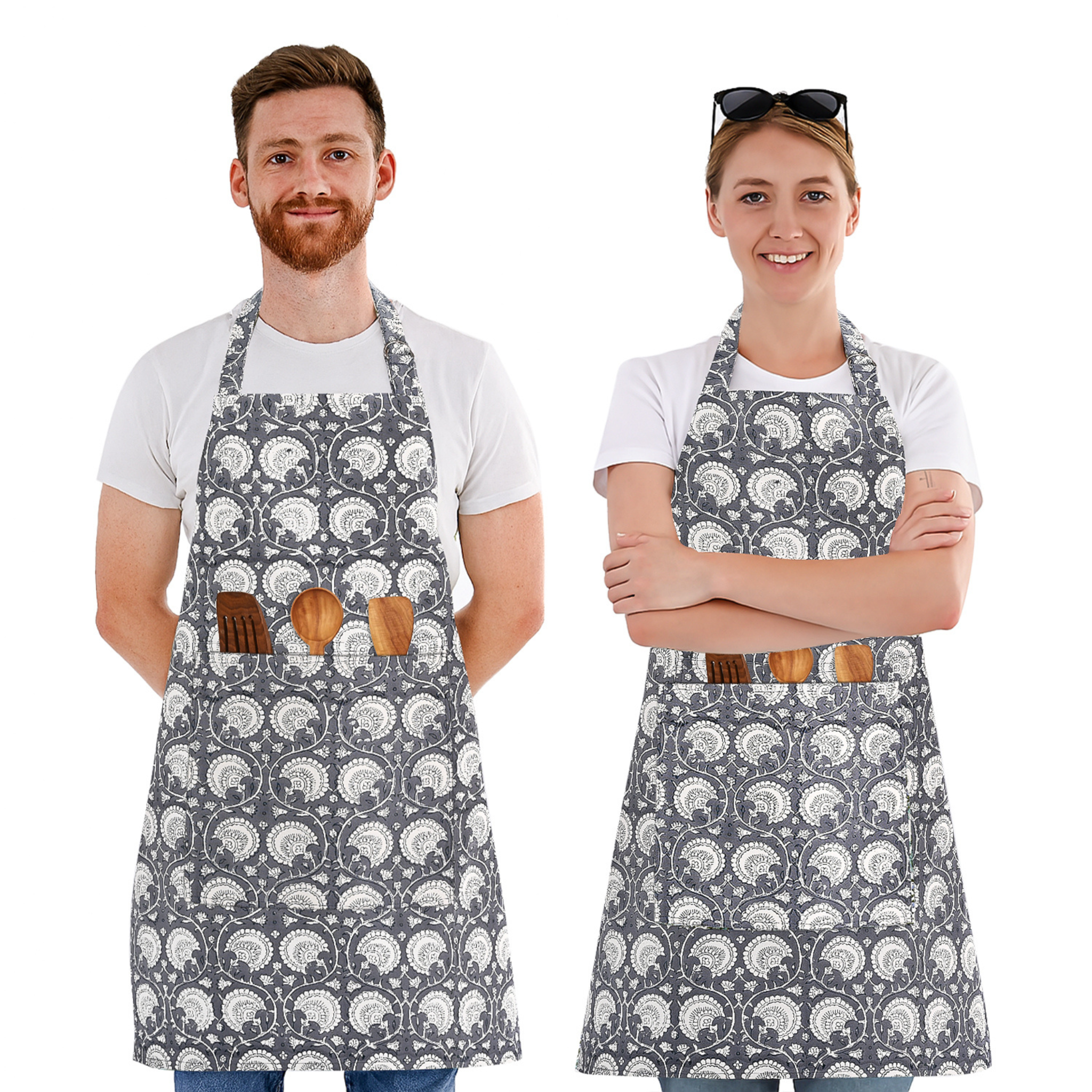 Two people wearing gray aprons with white patterns, standing side by side on a white background.