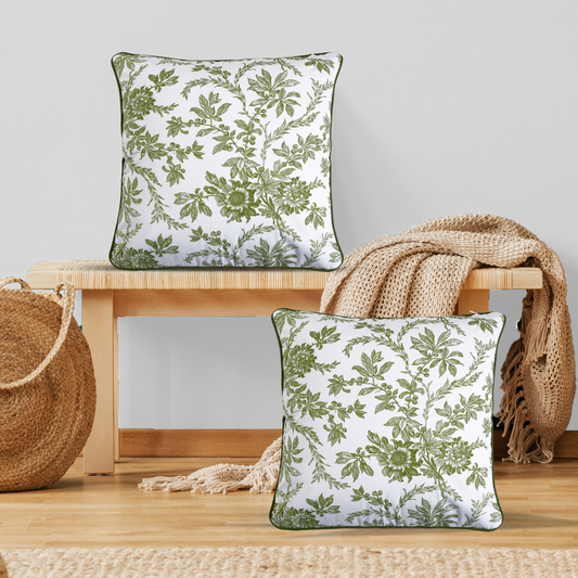 Two green floral-patterned pillows on a wooden surface with a neutral background