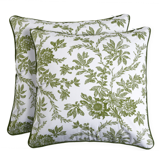 Two green floral-patterned pillows on a white background
