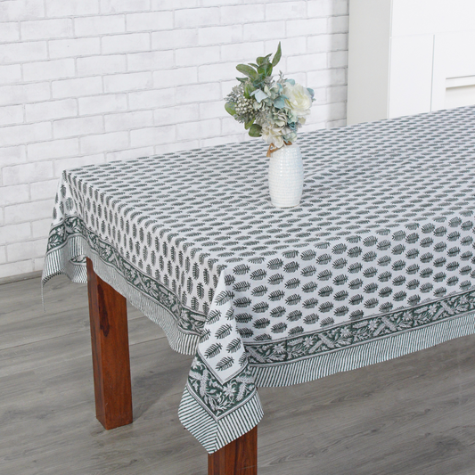 Tablecloth with a geometric pattern on a wooden table against a white brick wall.