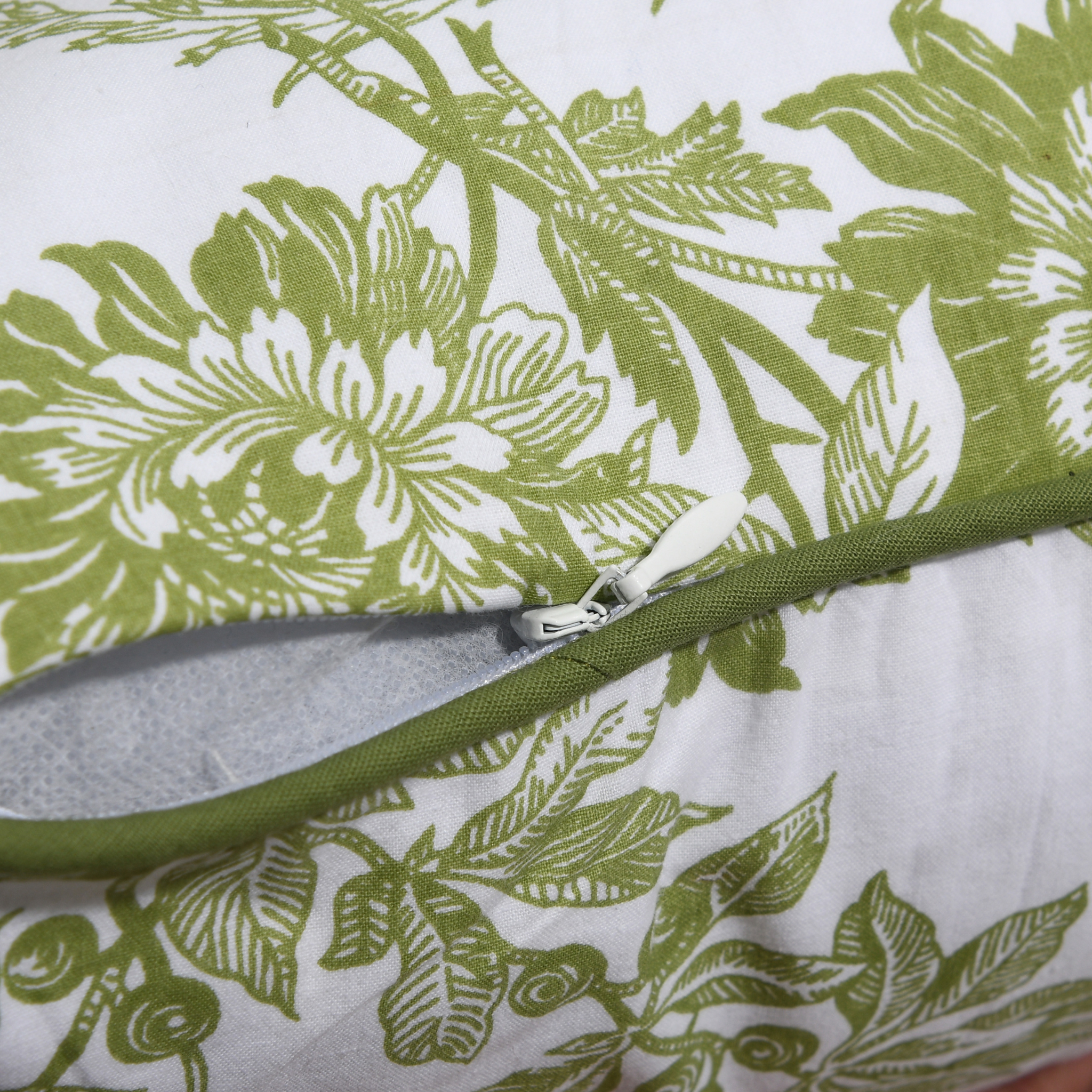 Close-up of a green floral-patterned fabric with a zipper.
