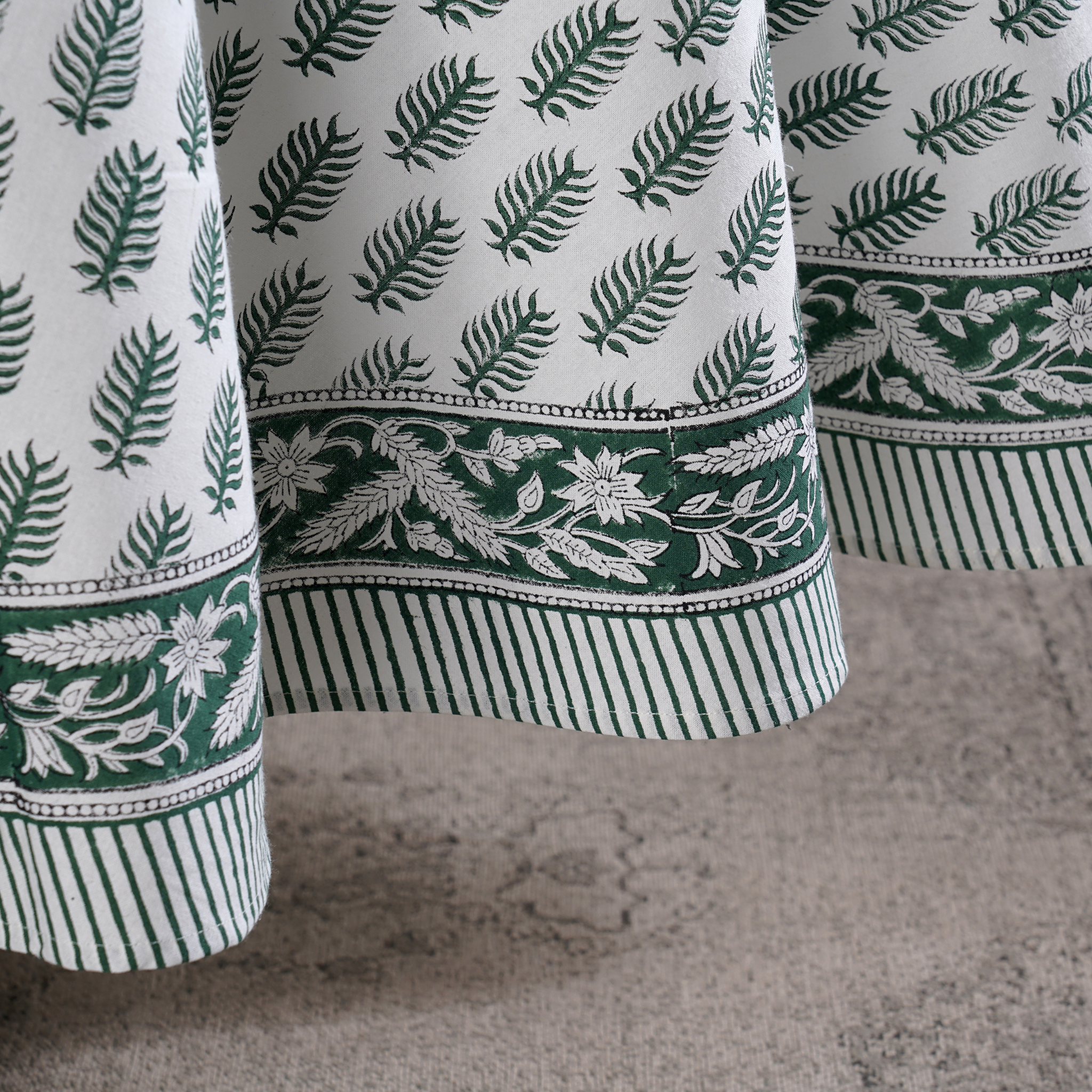 Close-up of green and white patterned fabric on a textured surface