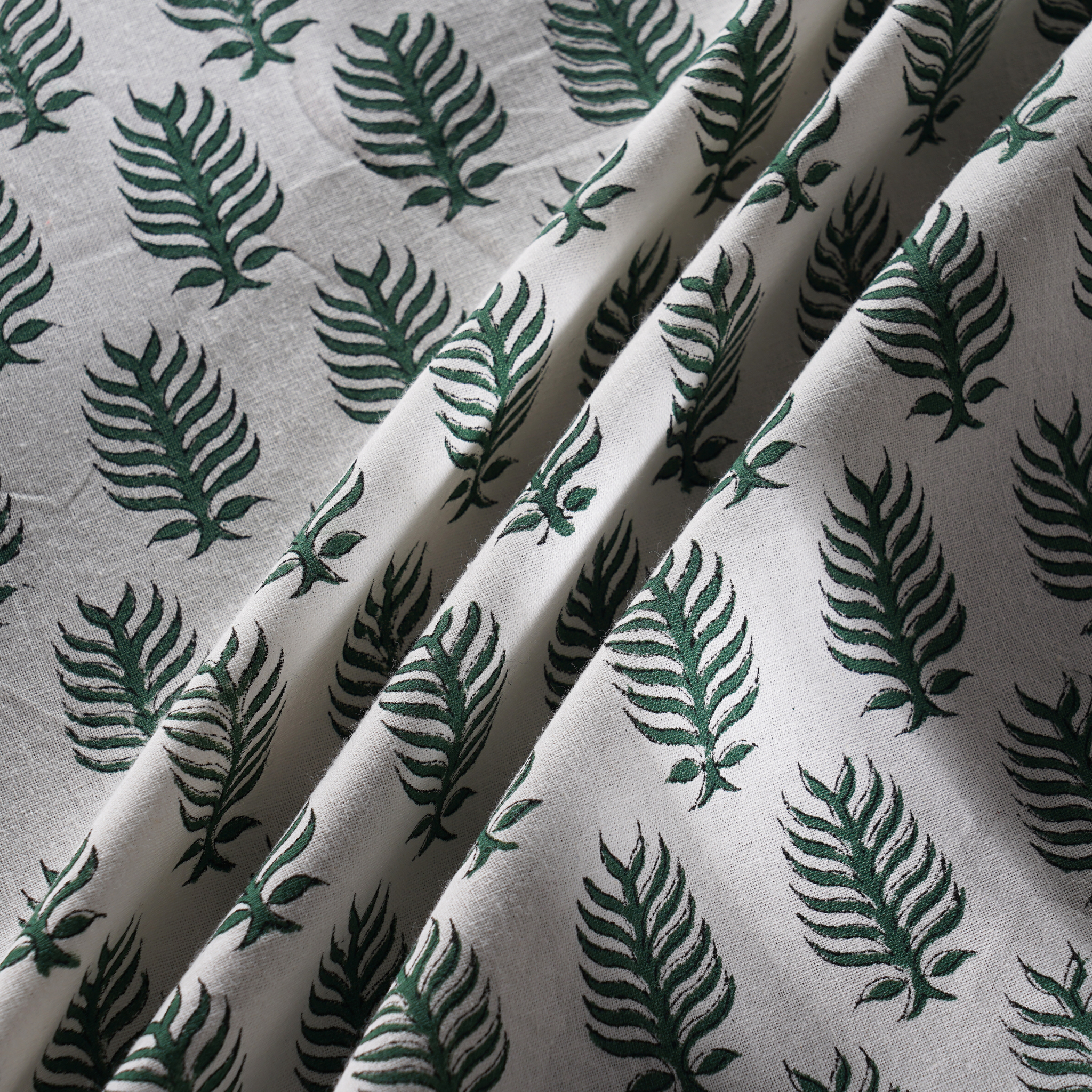 Fabric with green leaf pattern on a white background