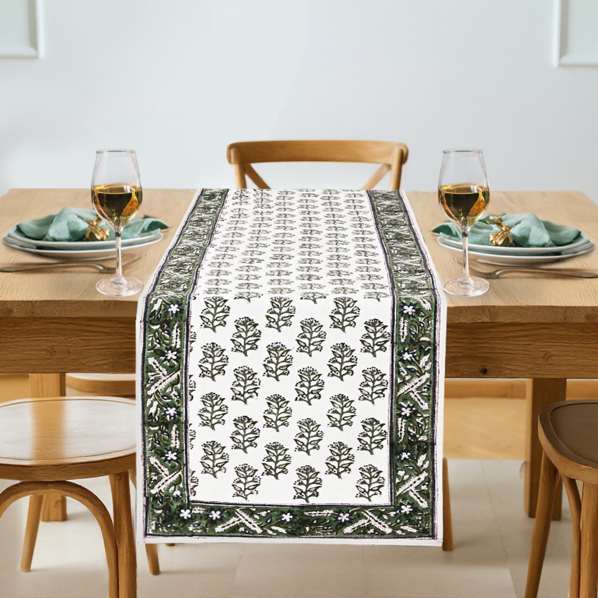 Dining table set with a decorative table runner featuring a leaf pattern.
