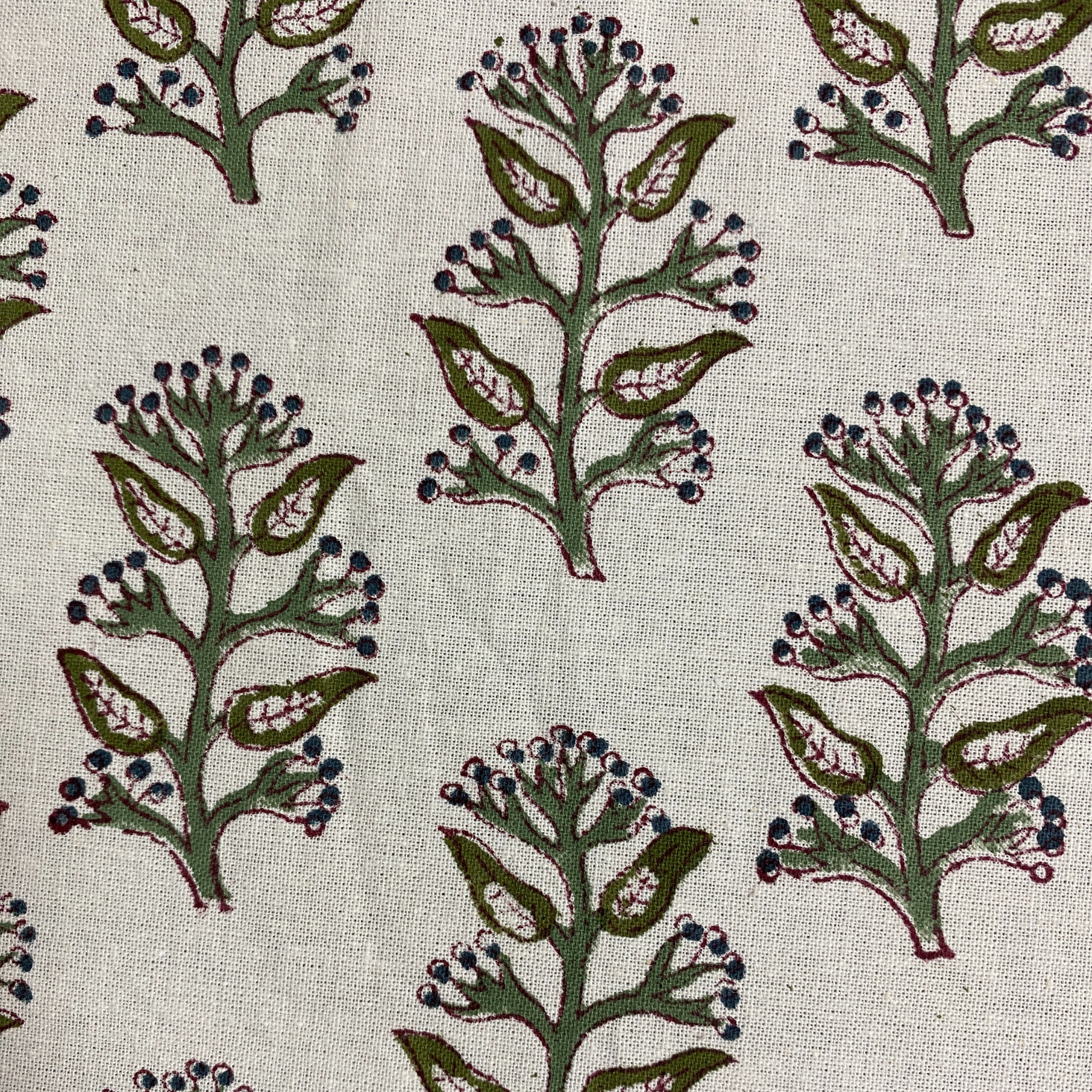 Pattern of green leaves and blue berries on a beige background