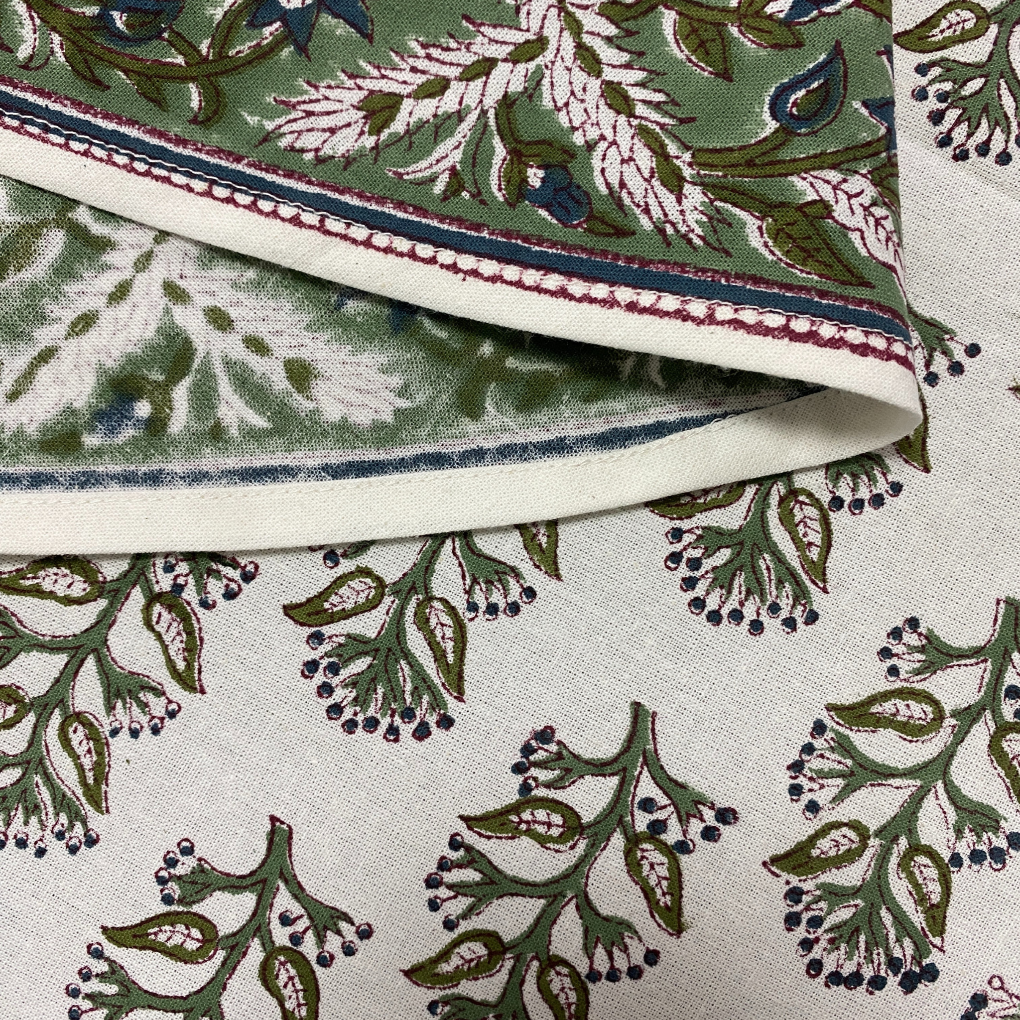Close-up of fabric with intricate green and white floral pattern
