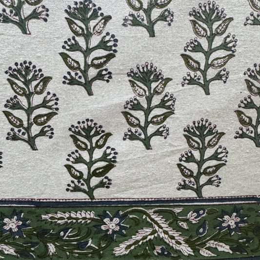 Patterned fabric with green floral design on a light background