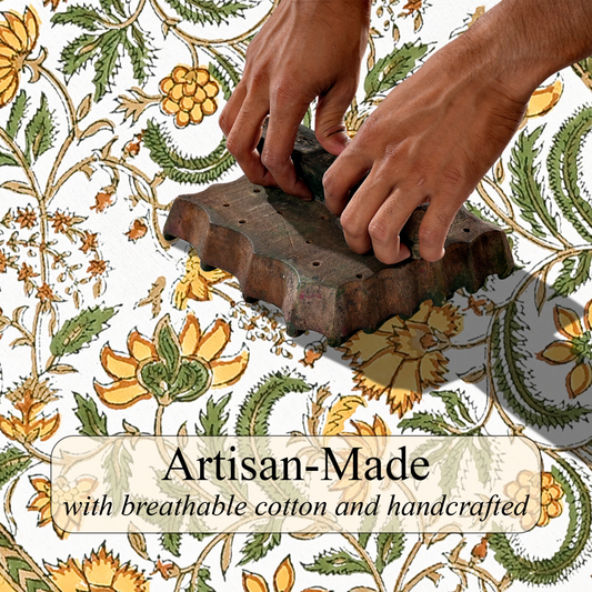 Hands using a traditional printing block on fabric with floral patterns and 'Artisan-Made' text.