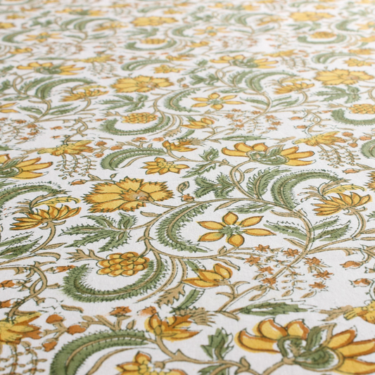 Close-up of floral patterned fabric with yellow and green flowers on a white background