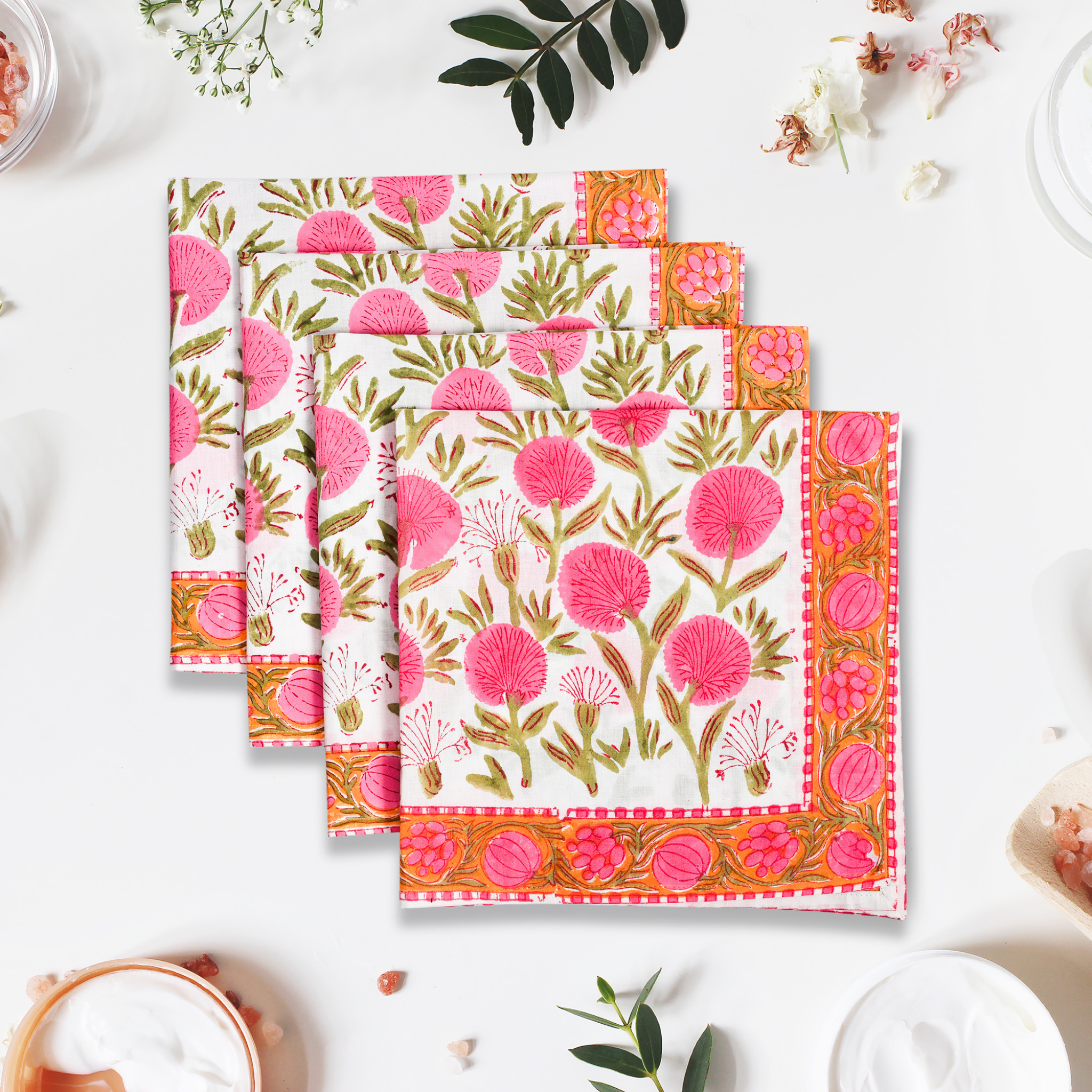 Set of floral patterned napkins on a white surface with decorative elements.
