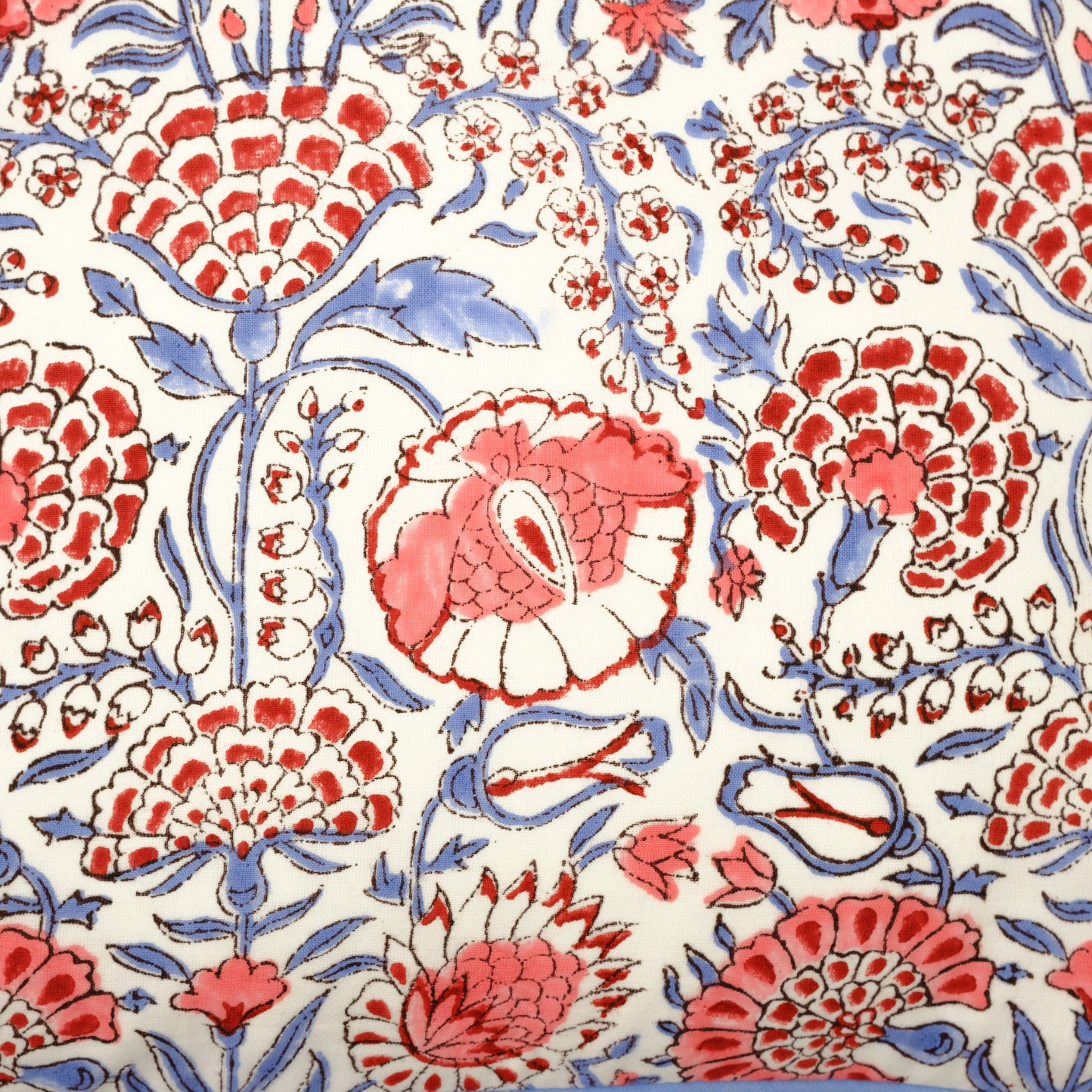 Close-up of a floral pattern with red, blue, and white colors on a white background.