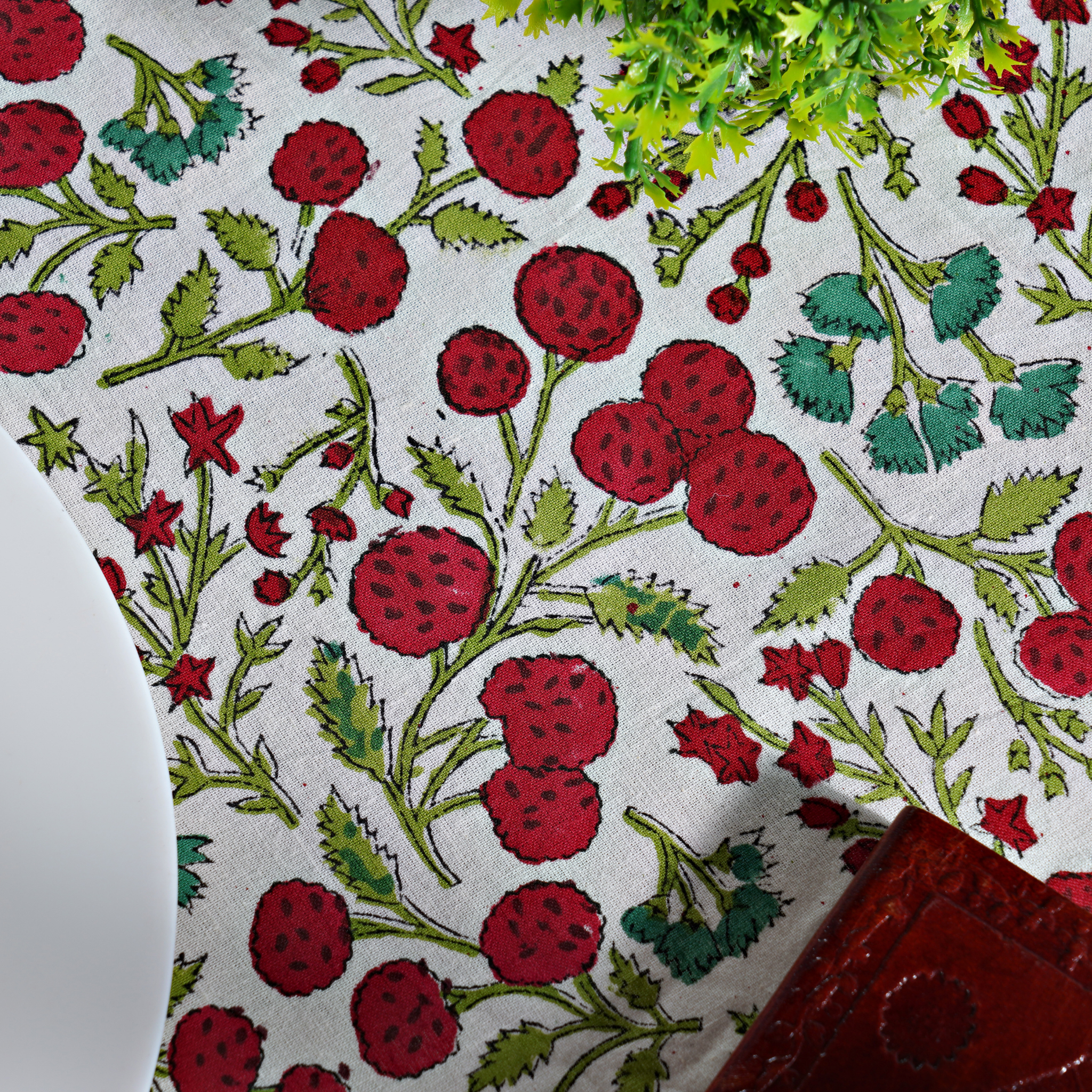 Close-up of a fabric with red berry pattern on a white background