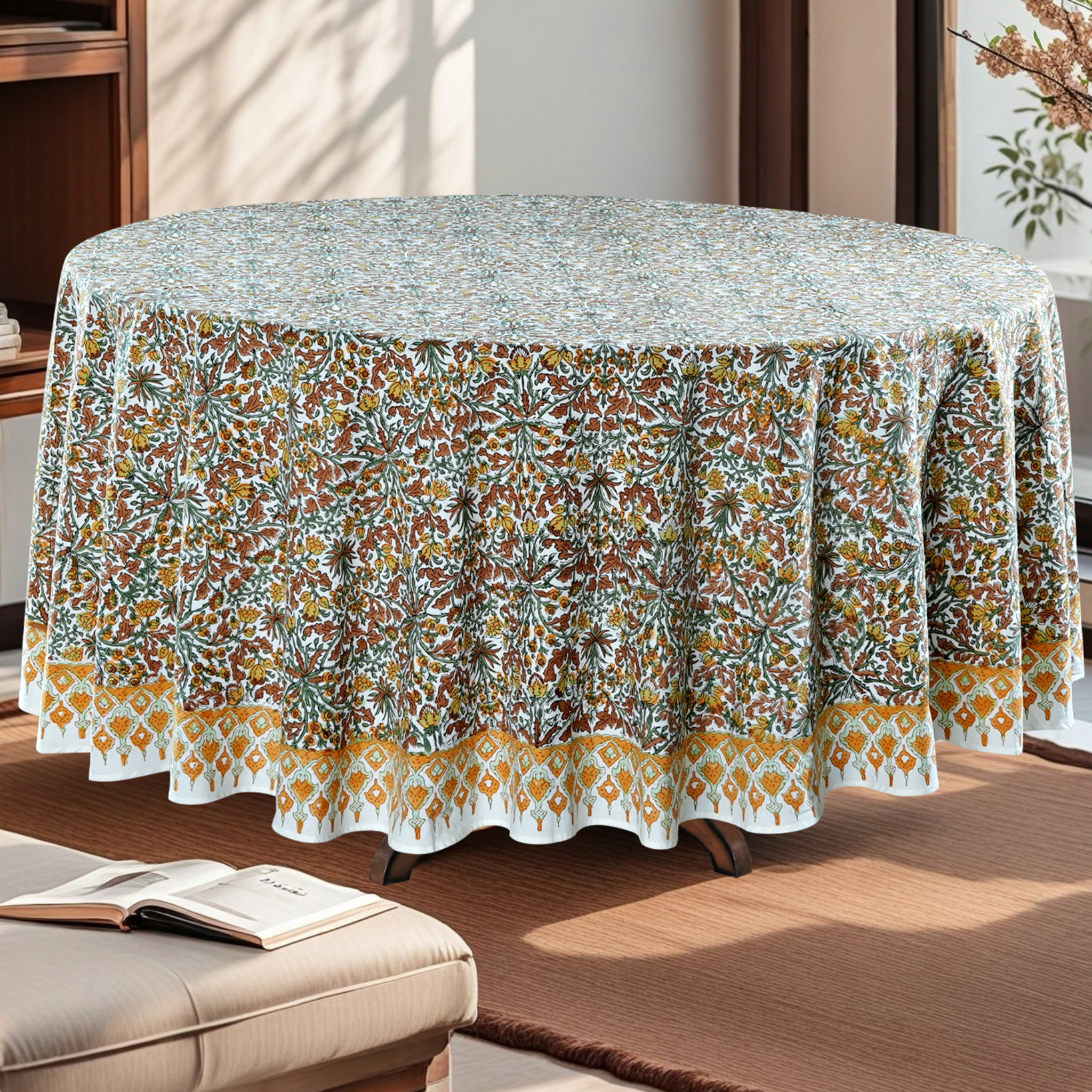 Round table with a floral patterned tablecloth in a living room setting.