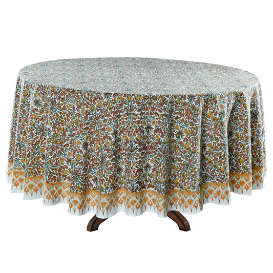 Round table with a floral patterned tablecloth on a white background