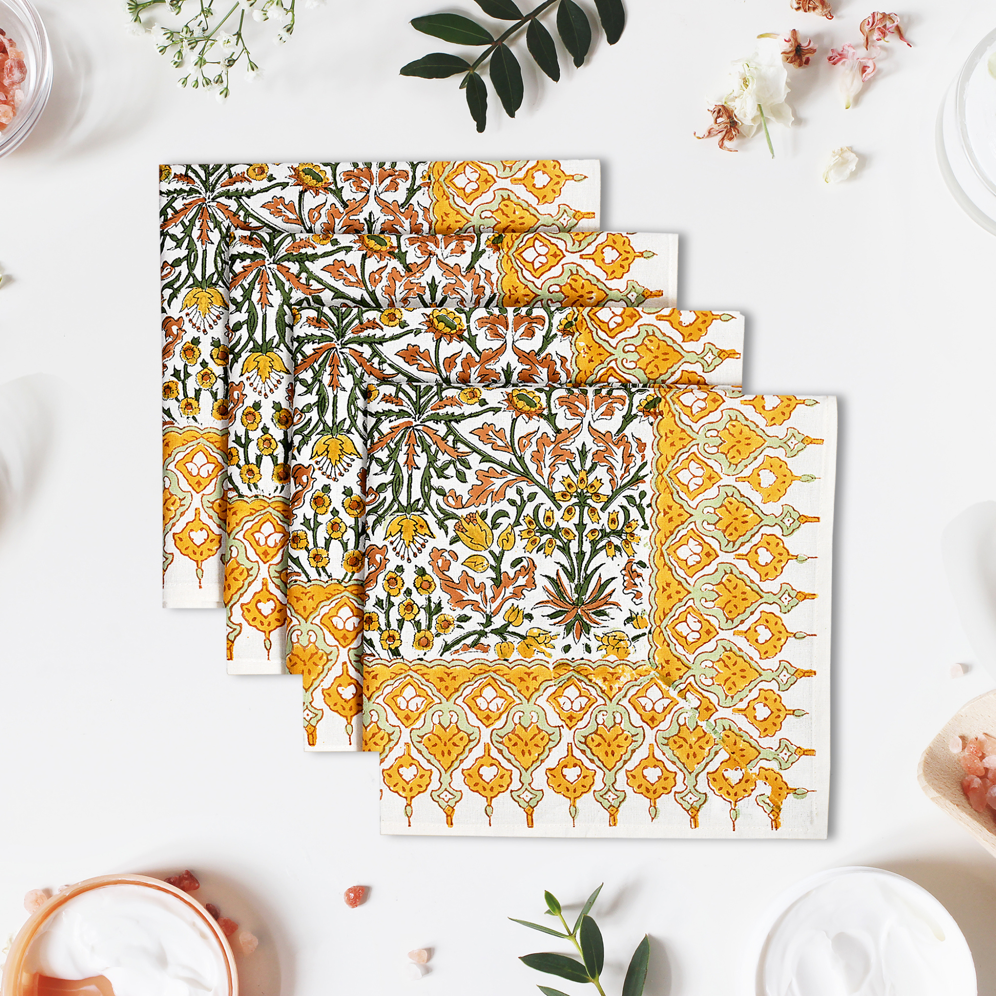 Set of four floral patterned placemats on a white surface with decorative elements.