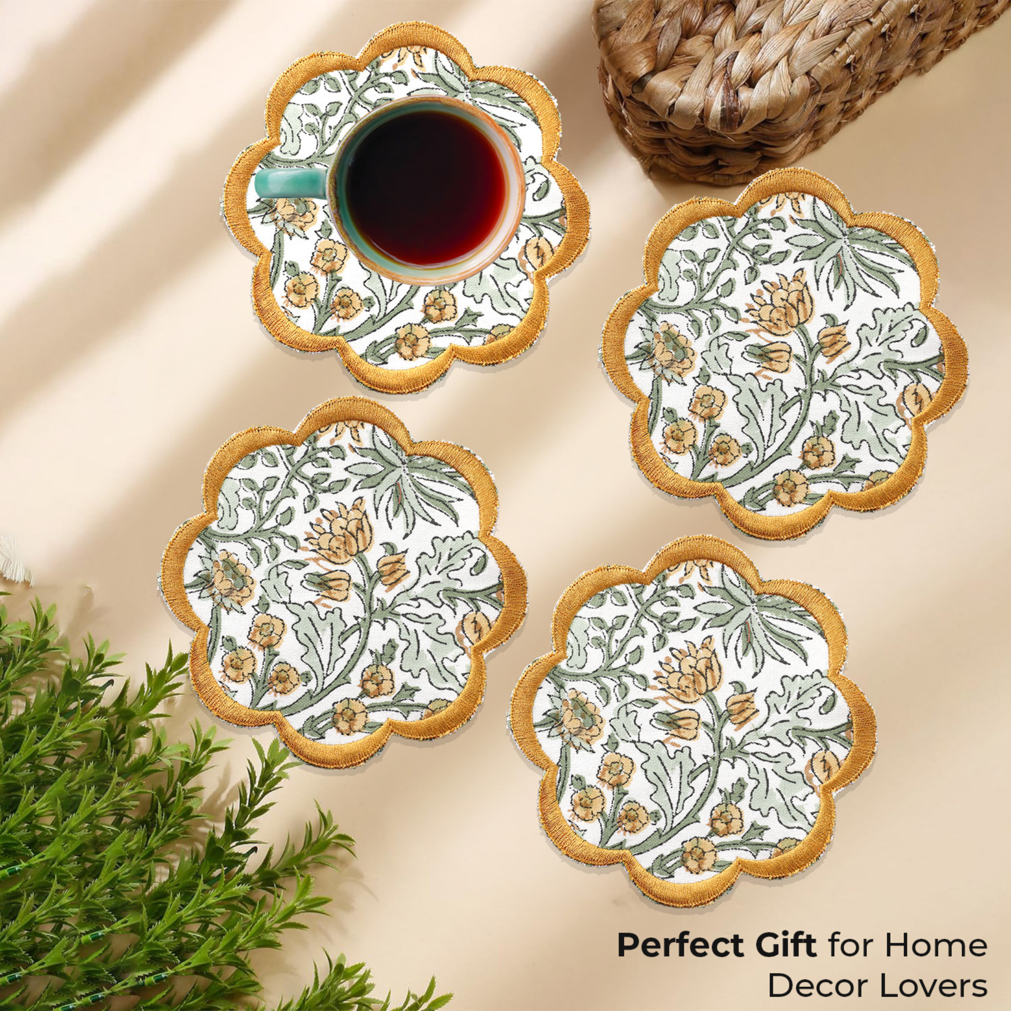 Set of four floral coasters with a cup of tea on a beige surface.