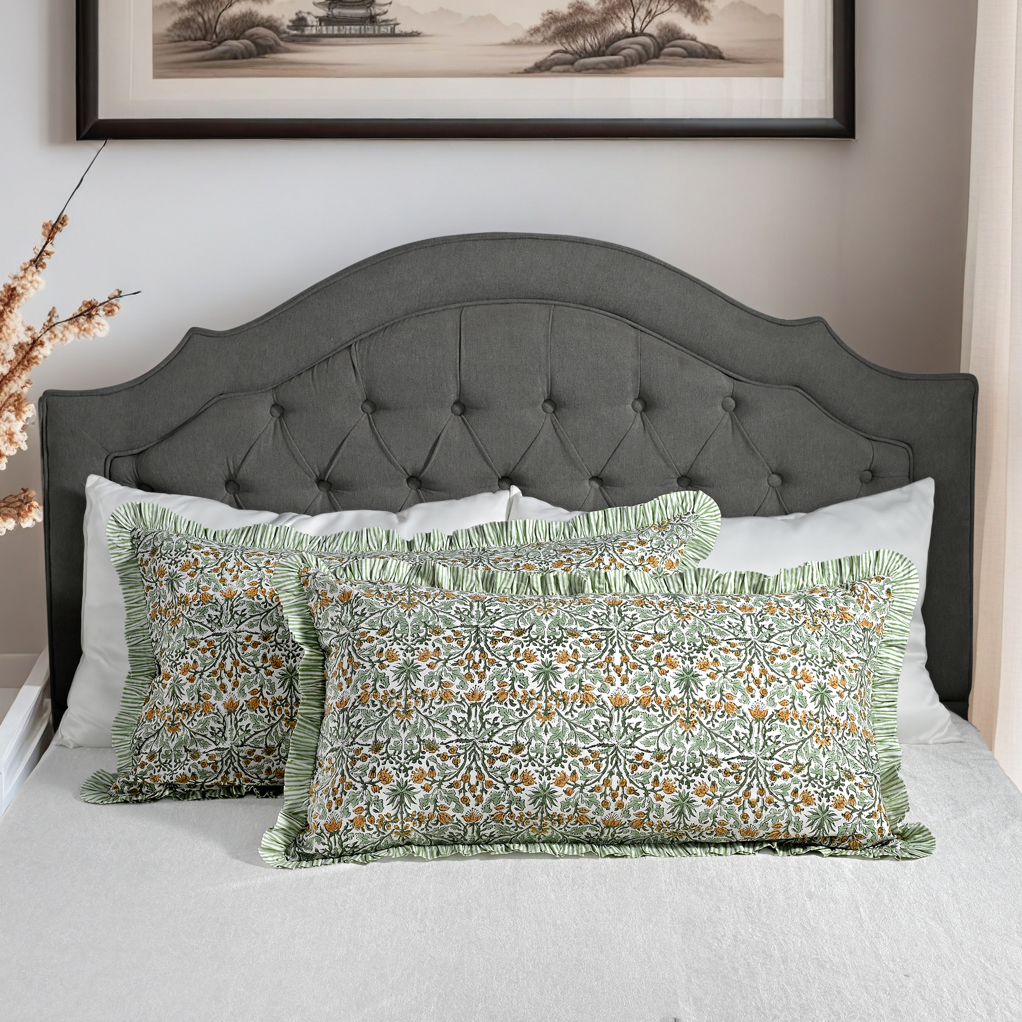 Large block print cotton pillows styled on gray upholstered bed.