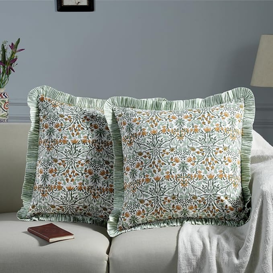Floral patterned pillows on a sofa with a neutral background