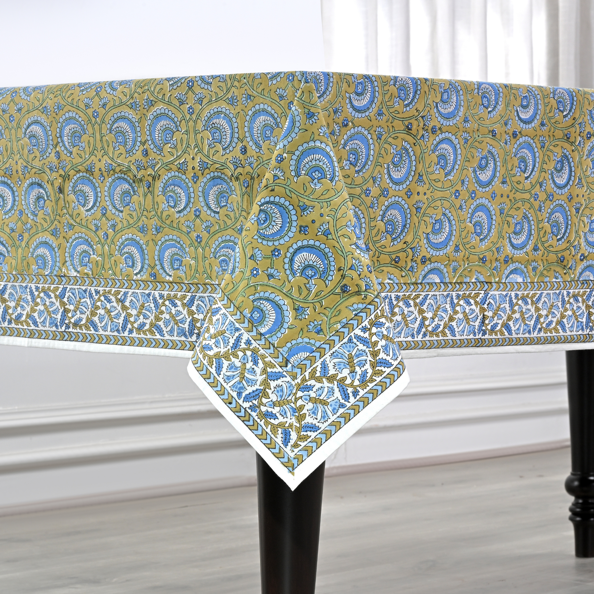 Patterned tablecloth on a table with a white curtain background