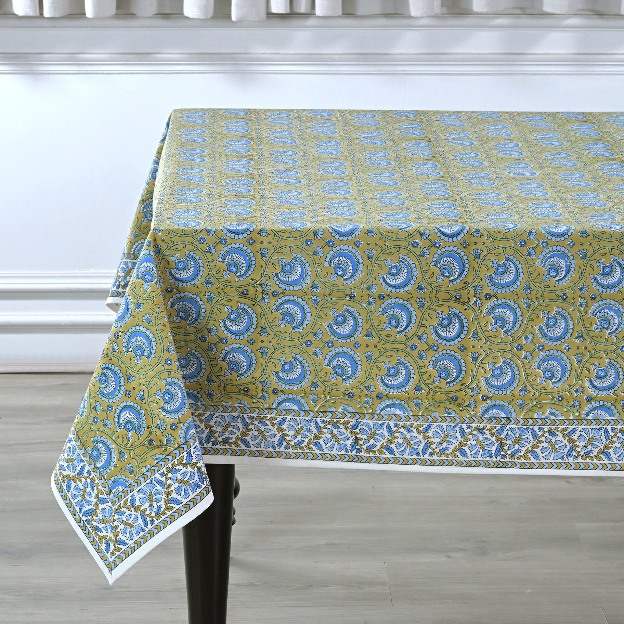 Tablecloth with blue and green pattern on a wooden table