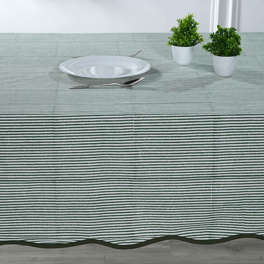 Tablecloth with black stripes on a table setting with a plate, cutlery, and plants.