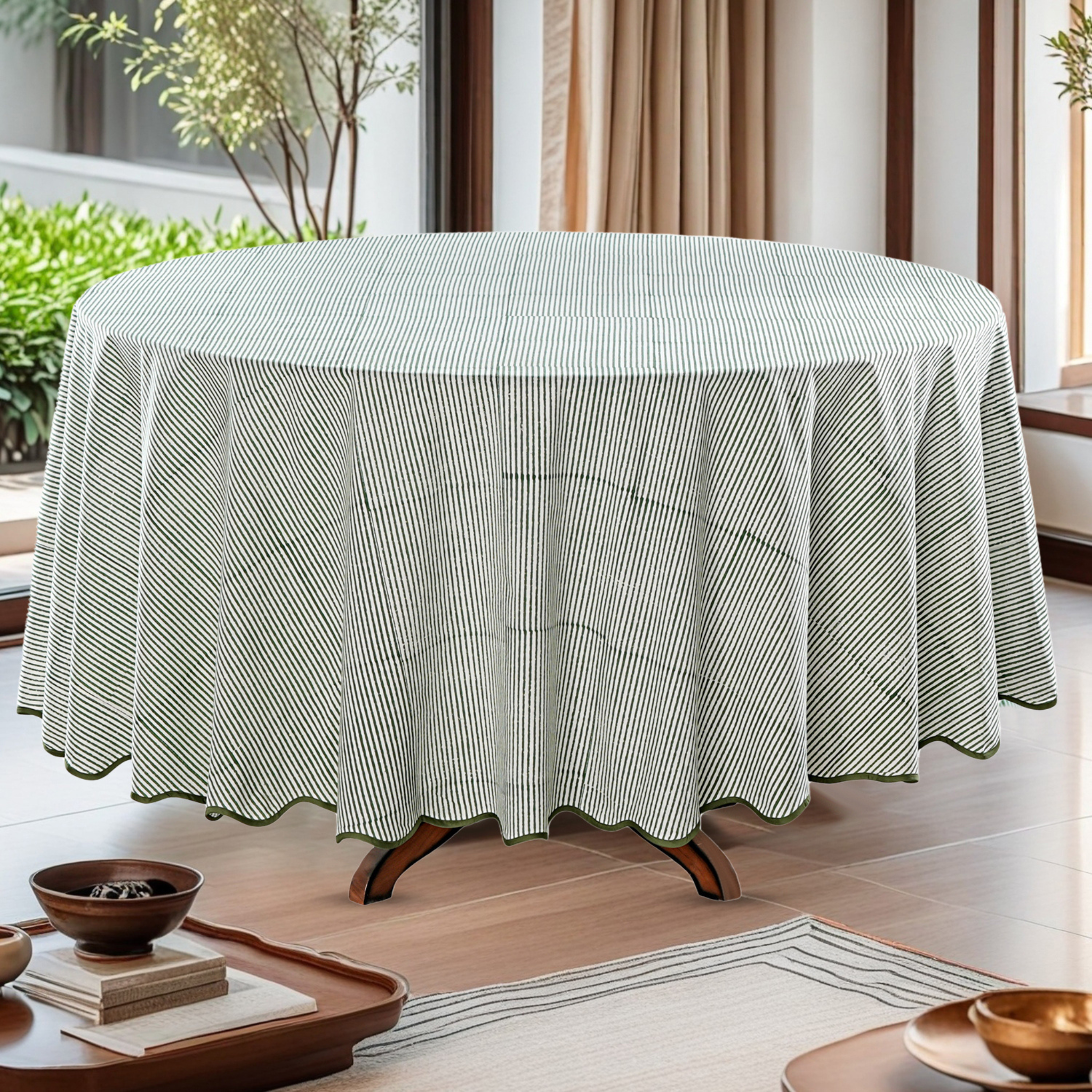 Round table with a striped tablecloth in a room with plants and curtains.